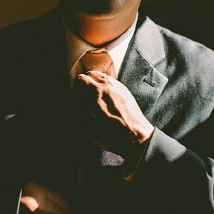 Mann mit Anzug richtet seine Krawatte